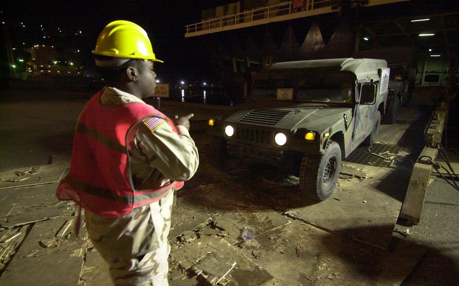 A soldier directs a Humvee onto the Northern Lights