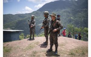 Guatemalan soldiers stand guard in Ampliación Nueva Reforma, Huehuetenango, Guatemala, where Mexicans from the town of Amatenango, Mexico fled due to cartel violence in their country across the border, Thursday, July 25, 2024. Some refugees are staying at the school and others at locals' homes. (AP Photo/Santiago Billy)