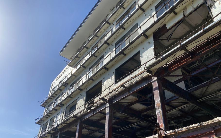 The damaged facade of a hotel building is seen from below.