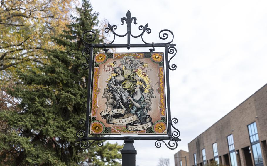 The new sign for the Man Full of Trouble Tavern in Philadelphia shows an Elizabethan-era man and woman hounded by angels and devils.