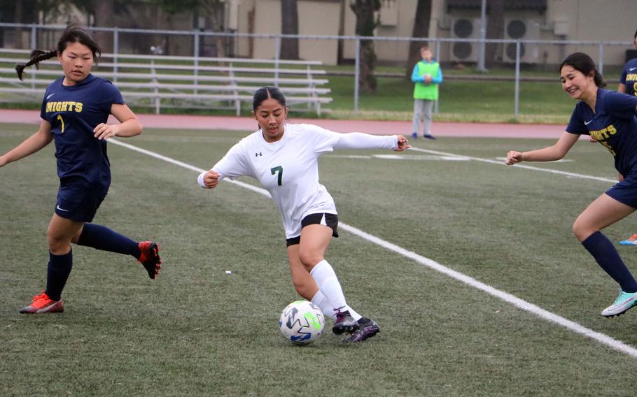 Edgren’s Charisse Reyes dribbles between Christian Academy Japan players during Tuesday’s girls Division II soccer match. The Knights won 3-0.