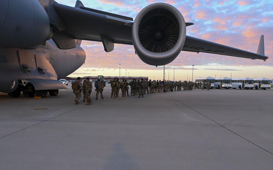 Soldiers exit a C-17 Globemaster III