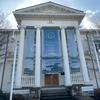 A white building with stone steps and columns that is now the Puget Sound Navy Museum.