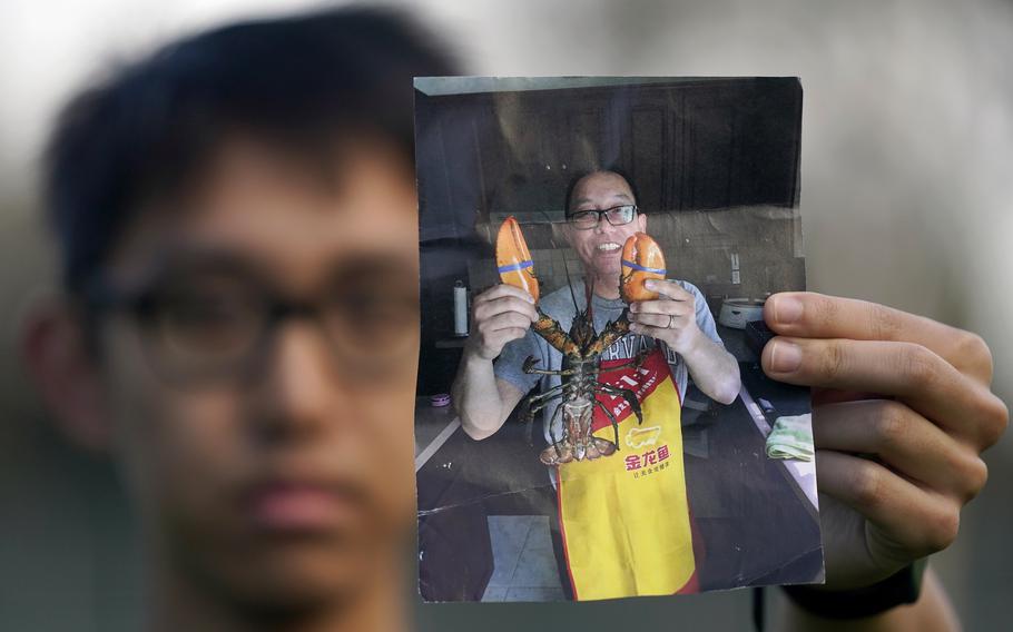 The son of a man the U.S. considers wrongfully detained in China holds a photo of his father pre-imprisonment.