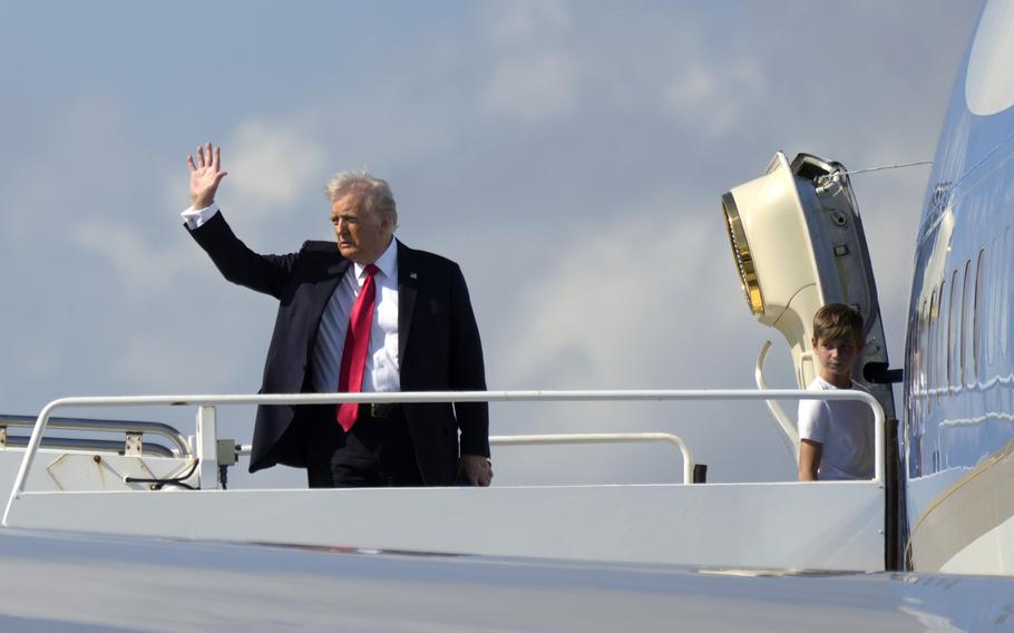 President Donald Trump, left, waves as he boards Air Force One with grandson Theodore.