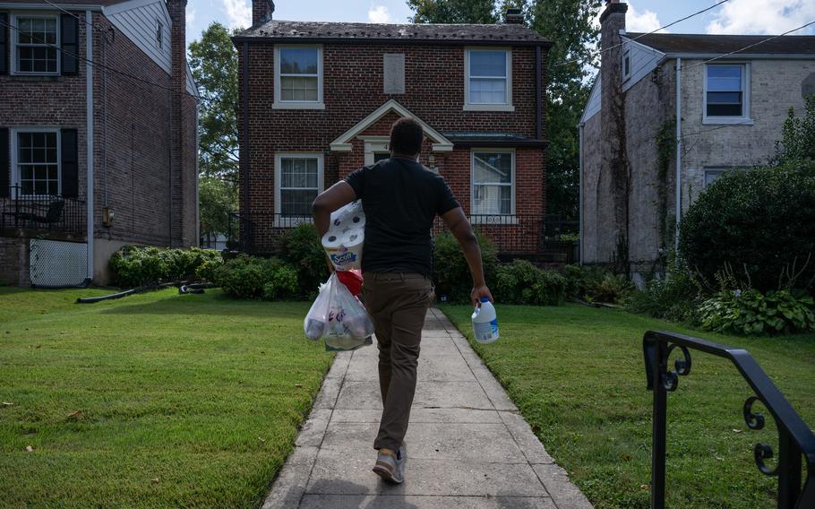 Larry Askew walks toward a house in Washington to drop off an Instacart delivery. He says he sometimes has to remind himself, “You’re taking somebody’s food to their house. It’s not really that hard. … Just do it!” 