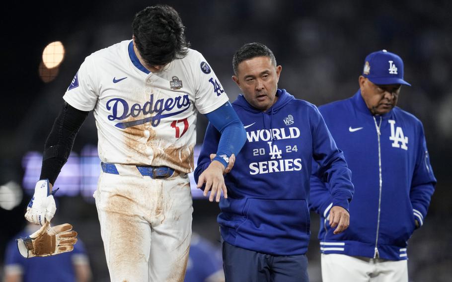 Shohei Ohtani is helped off the field after an ijury during the seventh inning in Game 2 of the World Series.