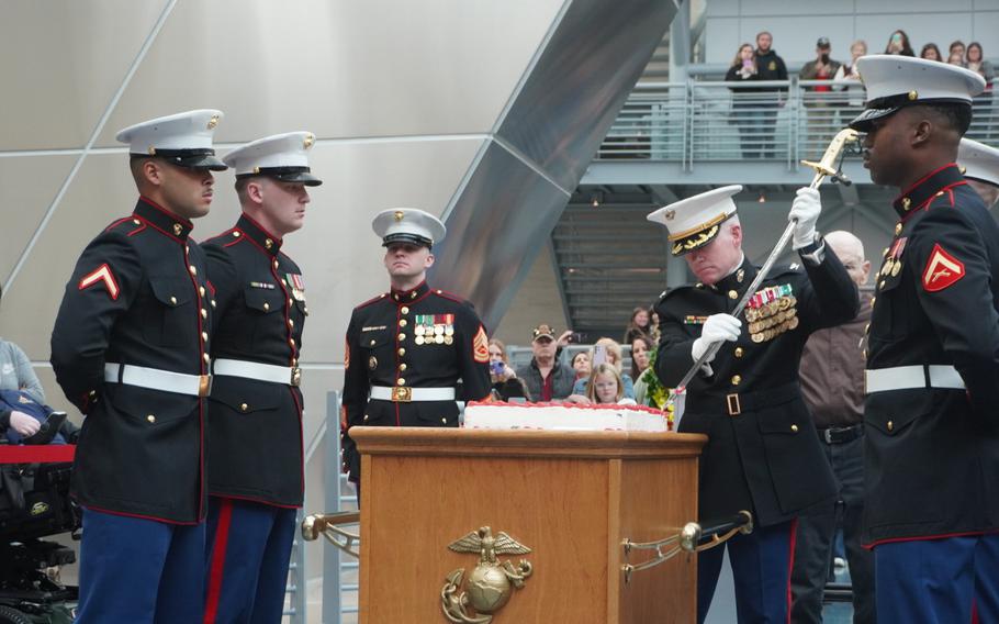 Col. (Ret.) Keil Gentry, director of the National Museum of the Marine Corps, cuts a birthday cake with a sword 