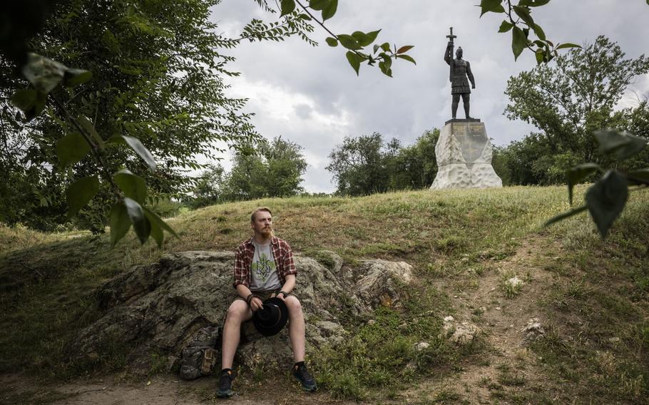 Soldier Viktor Mykola Havryliyk, 28, sits for a portrait in front of a statue of Sviatoslav the Brave, the Grand Prince of Kyiv, in a park in central Zaporizhzhia, Ukraine.