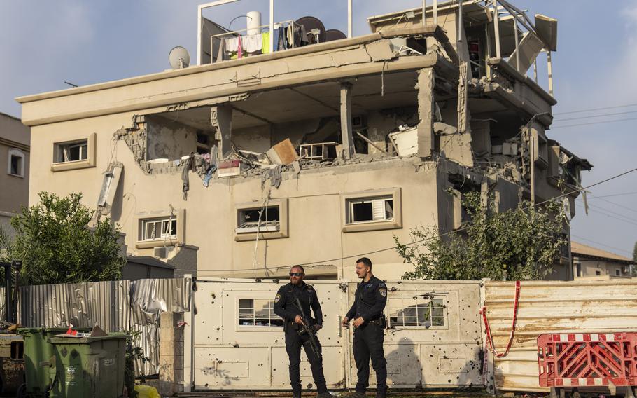 Two Israeli police officers stand in front of a damaged home, Nov. 2, 2024.