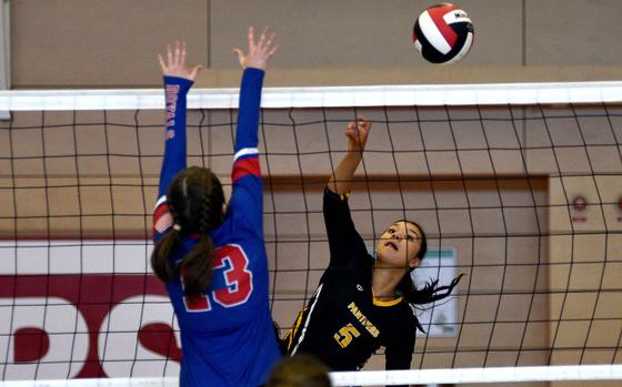 Stuttgart freshman Brooklyn Biles spikes the ball as Ramstein's Cara Arnold jumps at the net during a match on Oct. 5, 2024, at Kaiserslautern High School in Kaiserslautern, Germany.