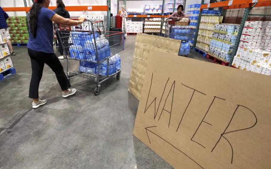 Shoppers load cases of water at Costco