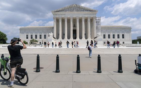 Visitors take photographs otuside the U.S. Supreme Court building in Washington on June 18, 2024.