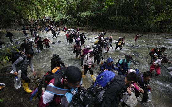 FILE - Migrants cross a river during their journey through the Darien Gap from Colombia into Panama, Oct. 15, 2022. (AP Photo/Fernando Vergara, File)