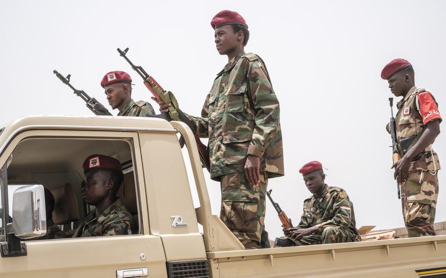 Sudan forces stand on the back of a military truck with weapons