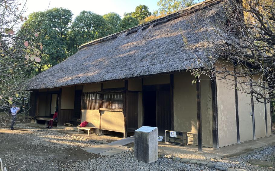 A cottage with a thatched roof stands apart.