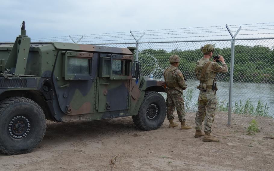 Two Texas National guard members near a humvee.