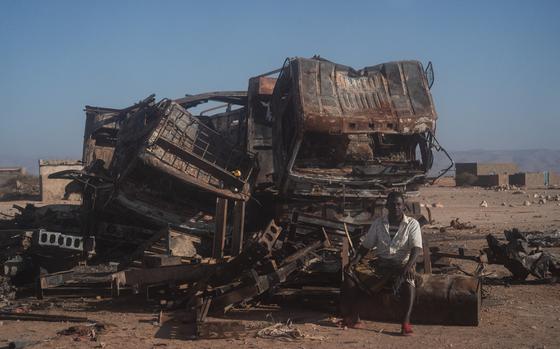 A man sits on the wreckage from a New Year's Eve attack by the Islamic State that involved 12 suicide bombers. MUST CREDIT: Carolyn Van Houten/The Washington Post