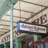 A hanging sign in front of Antoine’s in New Orleans reads “Antoine’s Restaurant Since 1840.”