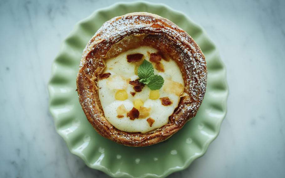 A tart with mango custard and coconut flakes.