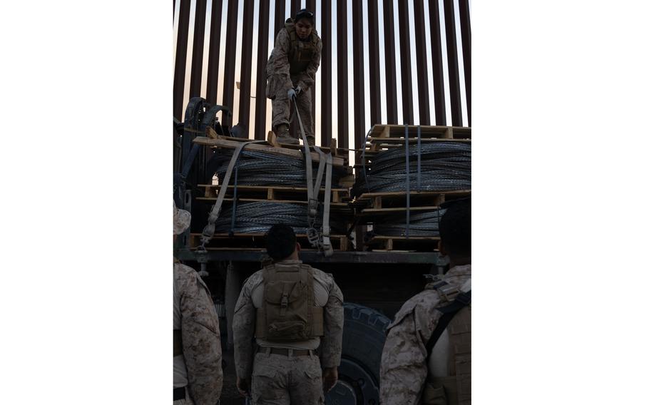 Marines load concertina wire onto a truck