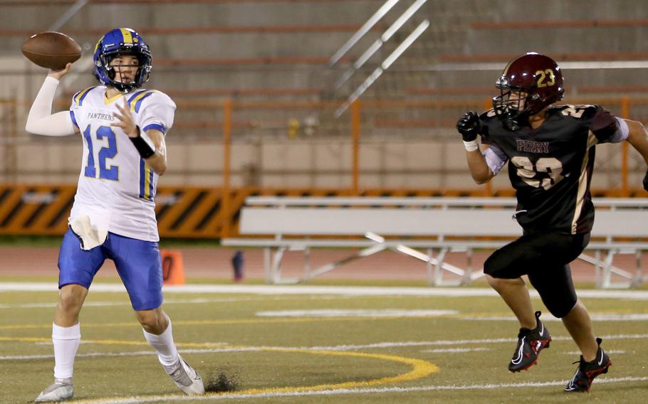 Yokota's Ethan Bricker throws on the run while being chased by Matthew C. Perry's Jordan Falcon.