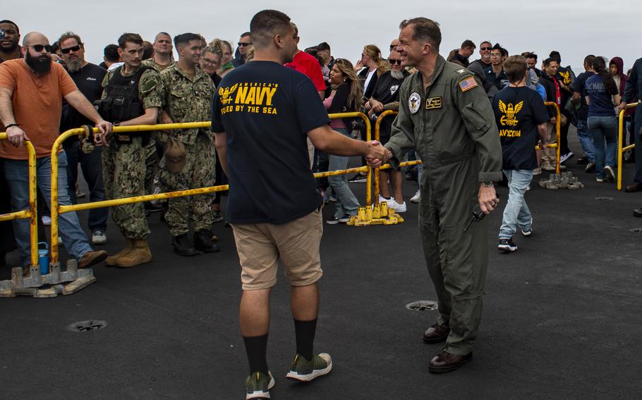 Capt. Matthew Thomas, commanding officer of Nimitz-class aircraft carrier USS Carl Vinson (CVN 70), shakes hands with Xavier Gilford, a native of Mira Mesa, Calif., after Gilford enlisted into the Navy while underway aboard the ship for a Family and Friends Day Cruise on Saturday, Aug. 17, 2024. 