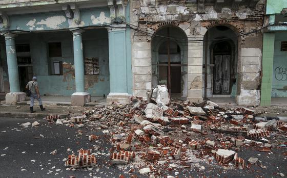 Debris from a building damaged by the passage of Hurricane Rafael covers the street in Havana, Cuba, Thursday, Nov. 7, 2024. (AP Photo/Ariel Ley)