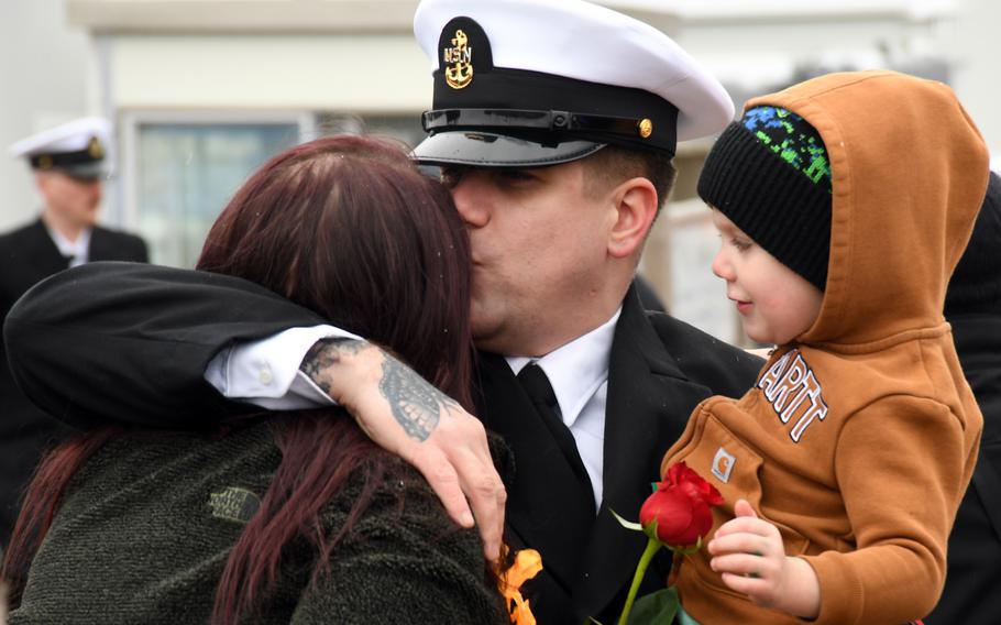 A sailor embraces his loved ones