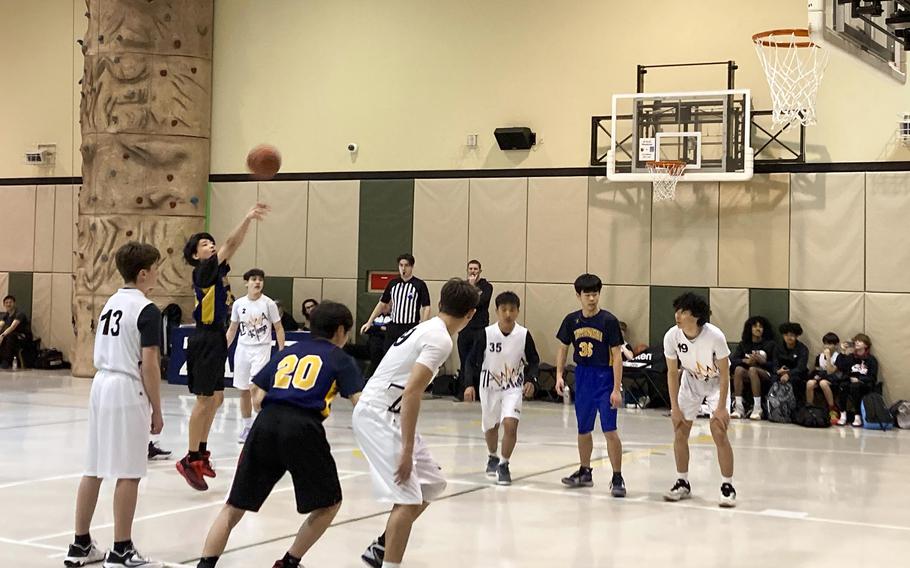 A student takes a free-throw shot.