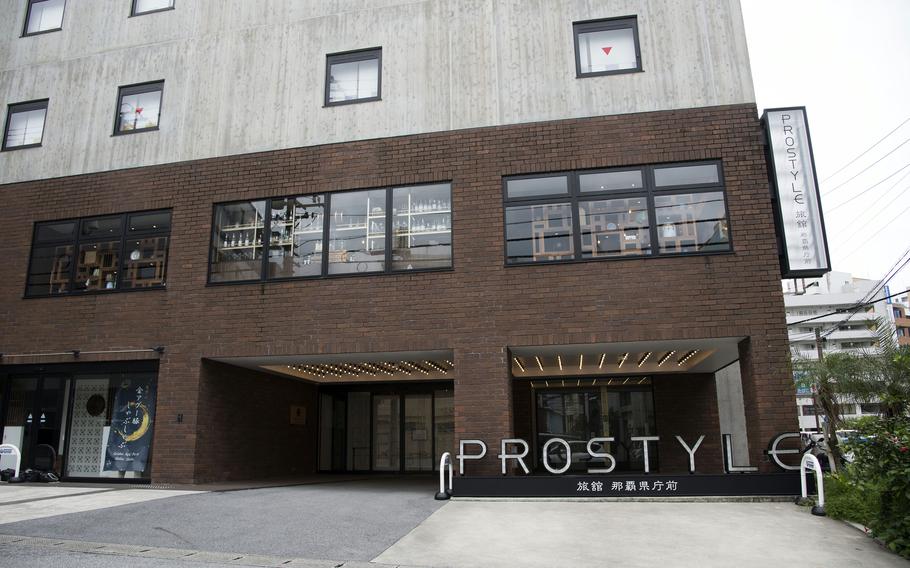 A brown brick hotel entrance is shown with the the name “Prostyle” in all capital letters outside. 