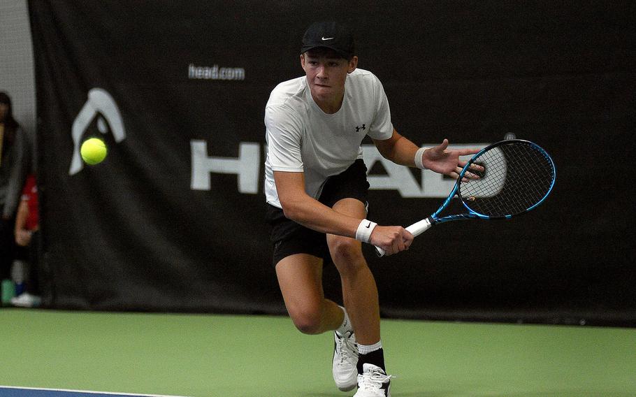 Vicenza's Sam Grady goes low to get a ball in a boys singles semifinal match against Kaiserslautern's Jace Martin during the DODEA European tennis championships on Oct. 20, 2023, at T2 Sports Health Club in Wiesbaden, Germany.