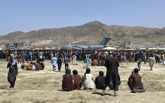 FILE - Hundreds of people gather near a U.S. Air Force C-17 transport plane at the perimeter of the international airport in Kabul, Afghanistan, Aug. 16, 2021. The Afghan man who speaks only Farsi represented himself in U.S. immigration court, and the judge denied him asylum. The Associated Press obtained a transcript of the hearing that offers a rare look inside an opaque and overwhelmed immigration court system where hearings are closed and judges are under pressure to move quickly given the backlog of 2 million cases. (AP Photo/Shekib Rahmani, File)