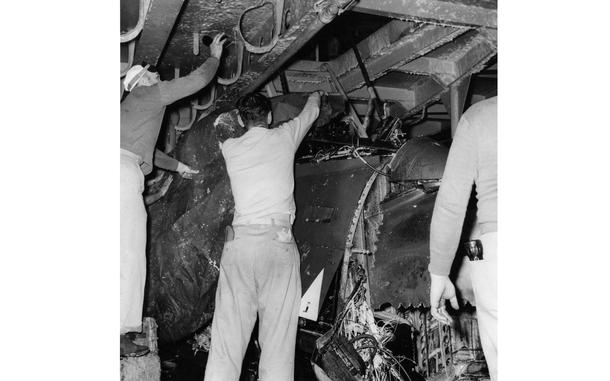 Aboard the USS Oriskany off the coast of Okinawa, June 28, 1955: Crew members of the USS Oriskany examine the crushed remains of the Banshee jet that crashed into the fantail of the attack aircraft carrier on June 22. The Navy Banshee - coming in for a landing that day - slid into the groove blinking its wing lights as it dipped for a landing. The landing signal officer with his electrically-lighted paddles began to guide it in – then hurriedly waved the paddles over his head as he saw the Jet sinking too low for a safe landing.
It was too late.
The jet flamed out. A wing dipped, and the Banshee, piloted by Lt. (jg) John R. Mitchell of Quincy, Mass. Plowed into the fantail at 125 miles an hour.
As high octane gas flamed into the night sky and the ship's fire crew ran to put them out, his fellow pilots gathered to remember Lt. Mitchell.
Then, the phone rang.

Read the 1955 eyewitness story of Lt. Mitchell's crash here.

Looking for Stars and Stripes’ historic coverage? Subscribe to Stars and Stripes’ historic newspaper archive! We have digitized our 1948-1999 European and Pacific editions, as well as several of our WWII editions and made them available online through https://starsandstripes.newspaperarchive.com/

META TAGS: U.S. Navy; aircraft carrier; F2H-2 Banshees; USS Oriskany; CVA-34; jet; accident; 