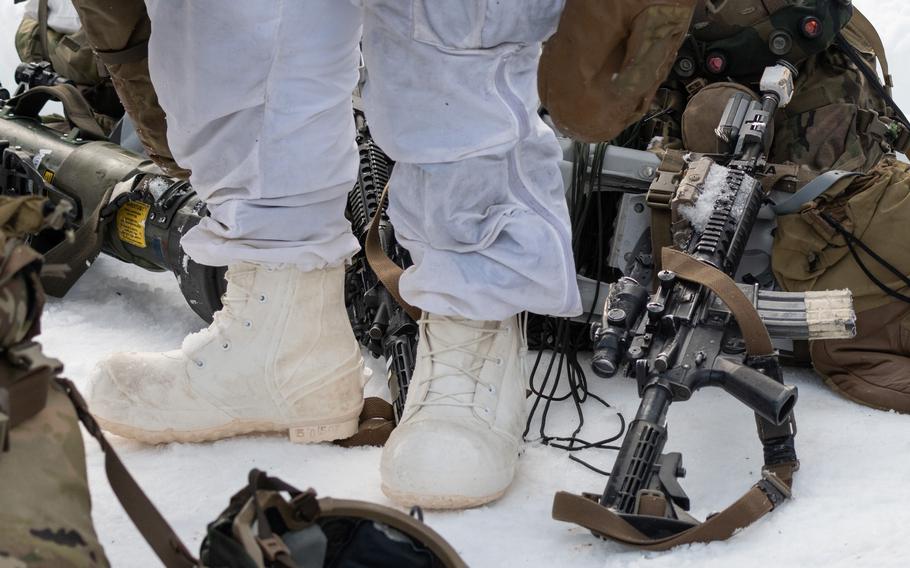 A soldier’s white boots are shown against artillery and snow.