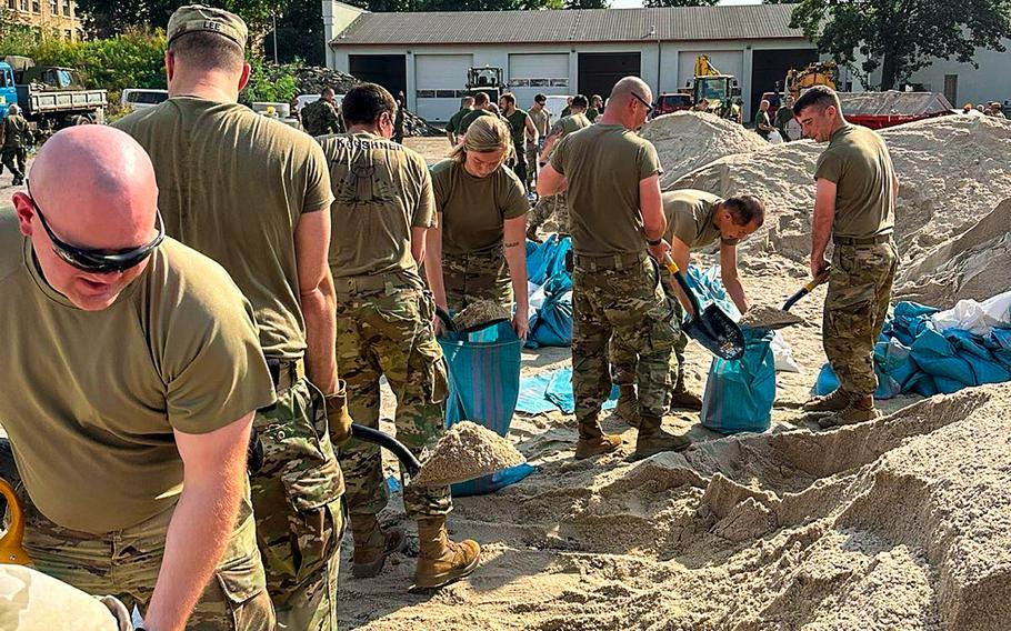 U.S. and Polish soldiers fill sandbags