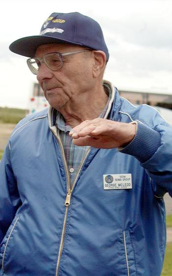 George McLeod's hand serves as a B-17 while he explains an episode during World War II. McLeod and several other veterans of the 100th Bomb Group visited their old airfield at Thorpe Abbots, England, June 22, 2002.