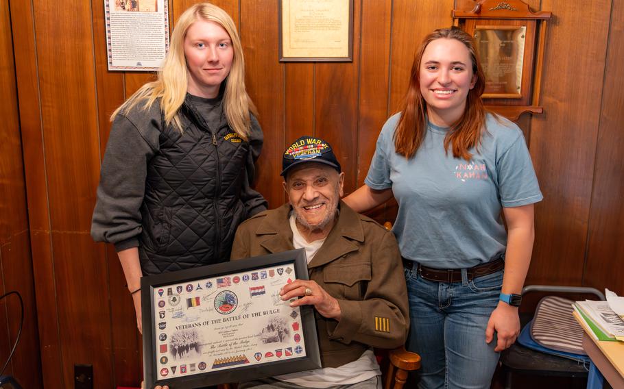 Kayla Smith, left, and Hannah Winton with Andy Valero, who showed them the certificate he was awarded in honor of his participation in the Battle of the Bulge. 