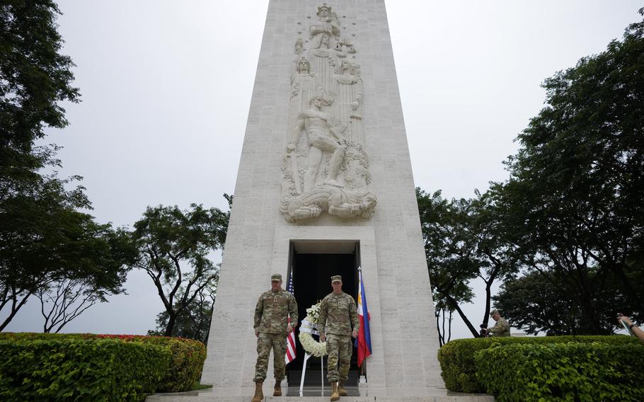 U.S. Maj. Gen. Marcus Evans, right, commanding general of the U.S. Army’s 25th Infantry Division and Sgt. Major Shaun Curry walk after a wreath laying rite to honor American soldiers 