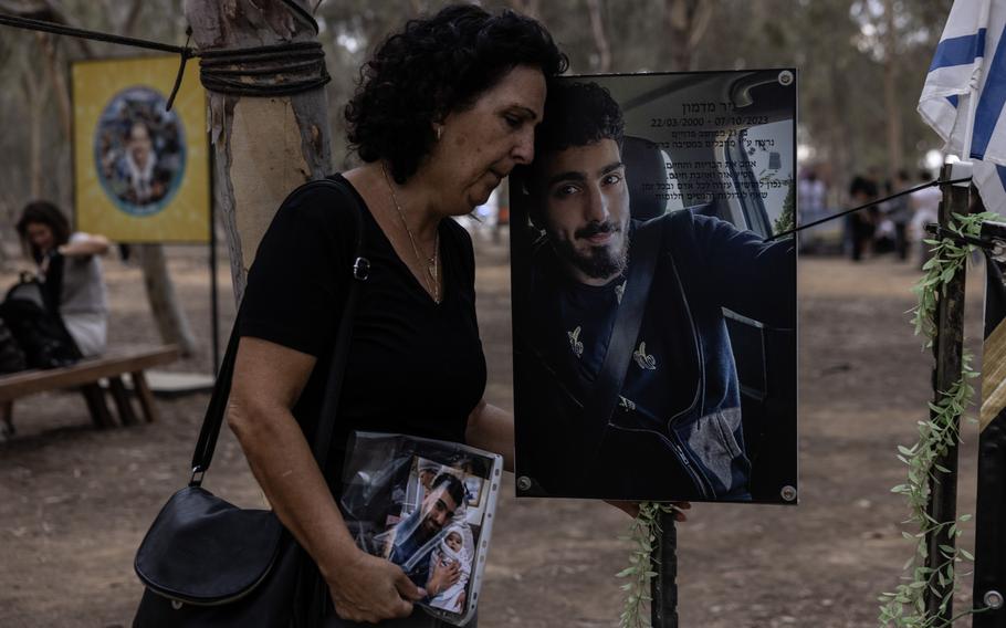 An Israeli woman leans her head on a large photo of her son who was killed in the Hamas attacks on Oct. 7, 2023.