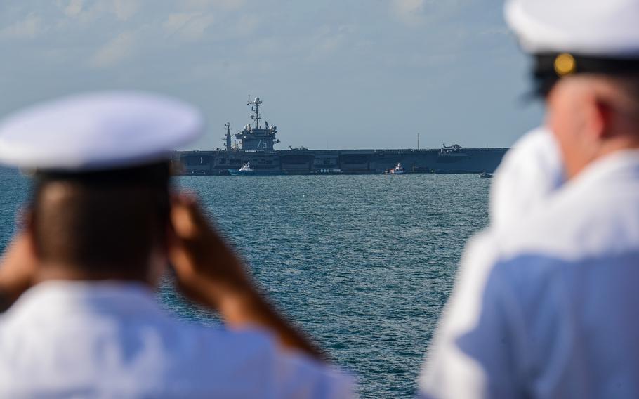 Sailors aboard the USS Bataan, an amphibious assault ship, look out at the USS Truman aircraft carrier as the Bataan pulls into the port of Miami for Fleet Week on Sunday, May 5, 2024. 