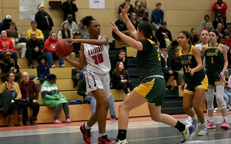 Raider Hazel Sanders looks to pass while SHAPE's Bella Smith defends during a Jan. 12, 2024, game at Kaiserslautern High School in Kaiserslautern, Germany.