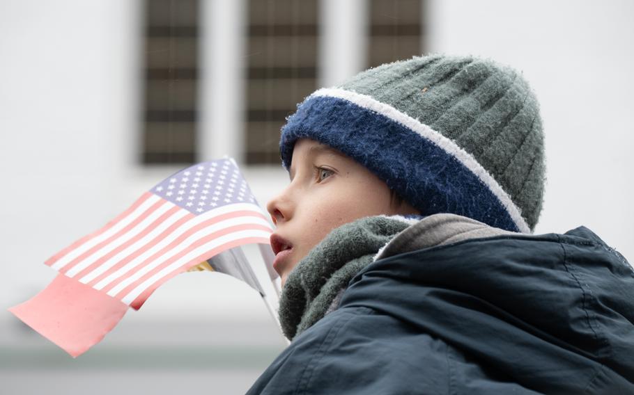 A boy waves a small American flag.