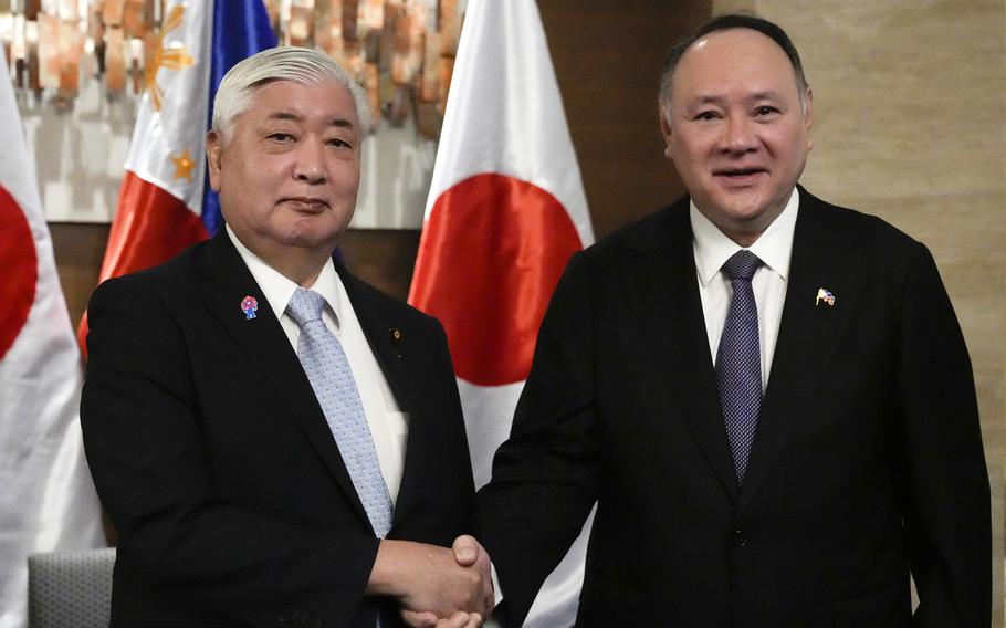 Philippine Defense Secretary Gilberto Teodoro, right, greets his Japanese counterpart Gen Nakatani.