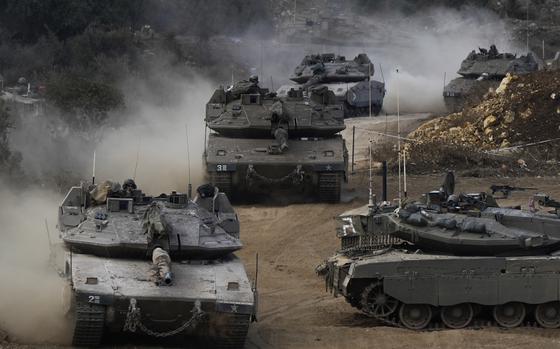 Israeli army tanks manoeuvre in a staging area in northern Israel near the Israel-Lebanon border, Tuesday, Oct. 1, 2024. (AP Photo/Baz Ratner)