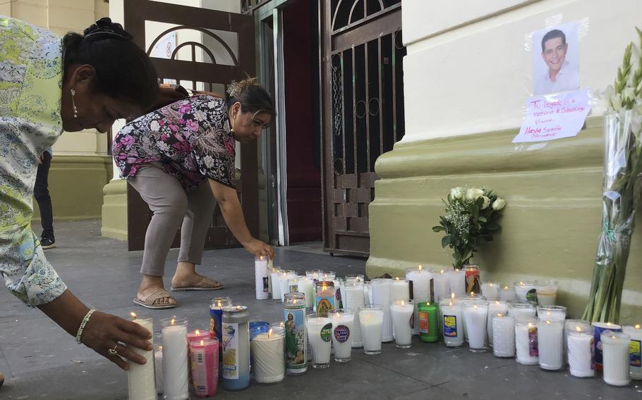 Supporters of slain Mayor Alejandro Arcos place candles and flowers at the entrance of the municipal building