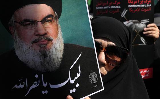 An Iranian worshipper holds up a poster of Hezbollah leader Sayyed Hassan Nasrallah, reading in Arabic: "At your service Nasrallah" during an anti-Israeli rally after Friday prayers in Tehran, Iran, Friday, Sept. 27, 2024. (AP Photo/Vahid Salemi)