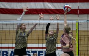 Aviano junior Addison Krajicek, left, and Balck Forest Academy Xofia Wood Pineda, middle, of the Gold team, defend agianst an attack at the net by Black Forest Academy Priscilla Sivonen of the Pink team during the 2024 DODEA-Europe All-Star volleyball matches on Nov. 9, 2024, at Ramstein High School on Ramstein Air Base, Germany.