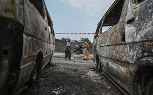 Residents walk by charred vehicles in Goma, Democratic republic of the Congo, Friday, Jan. 31, 2025. (AP Photo/Moses Sawasawa)