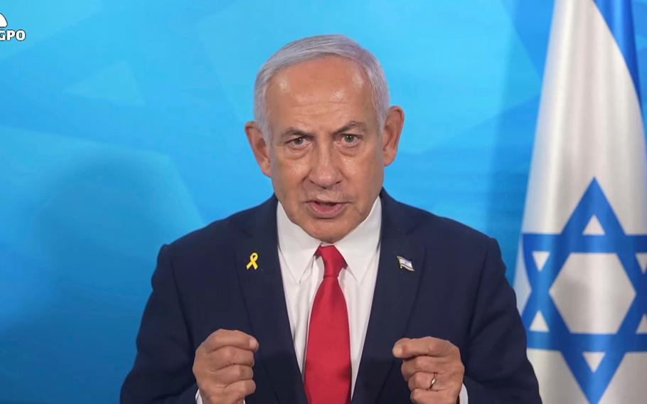 Netanyahu speaks in front of an Israeli flag.